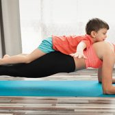 femme faisant du yoga avec son enfant sur le dos