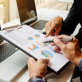 hommes d'affaires étudiant chiffres devant ordinateur