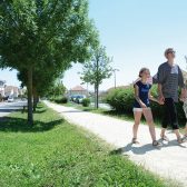 Femme se promenant tenant un enfant par la main de chaque côté d'elle