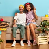 Couple mixte assis sur canapé au milieu des cartons
