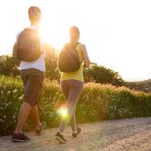 Couple de dos avec sac à dos sur un chemin de campagne