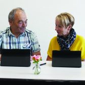 deux seniors homme et femme devant des tablettes